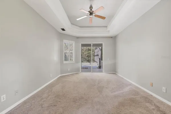 a view of a big room with windows and chandelier fan