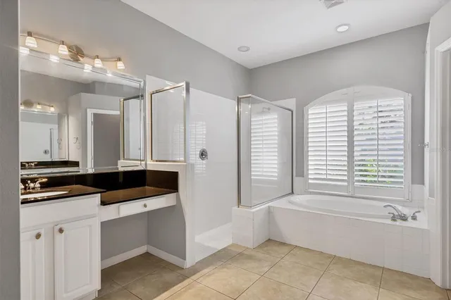 a bathroom with a tub a double vanity sink and mirror