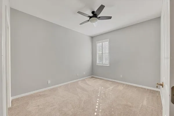 an empty room with a window and a fan