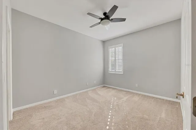 an empty room with a window and a fan