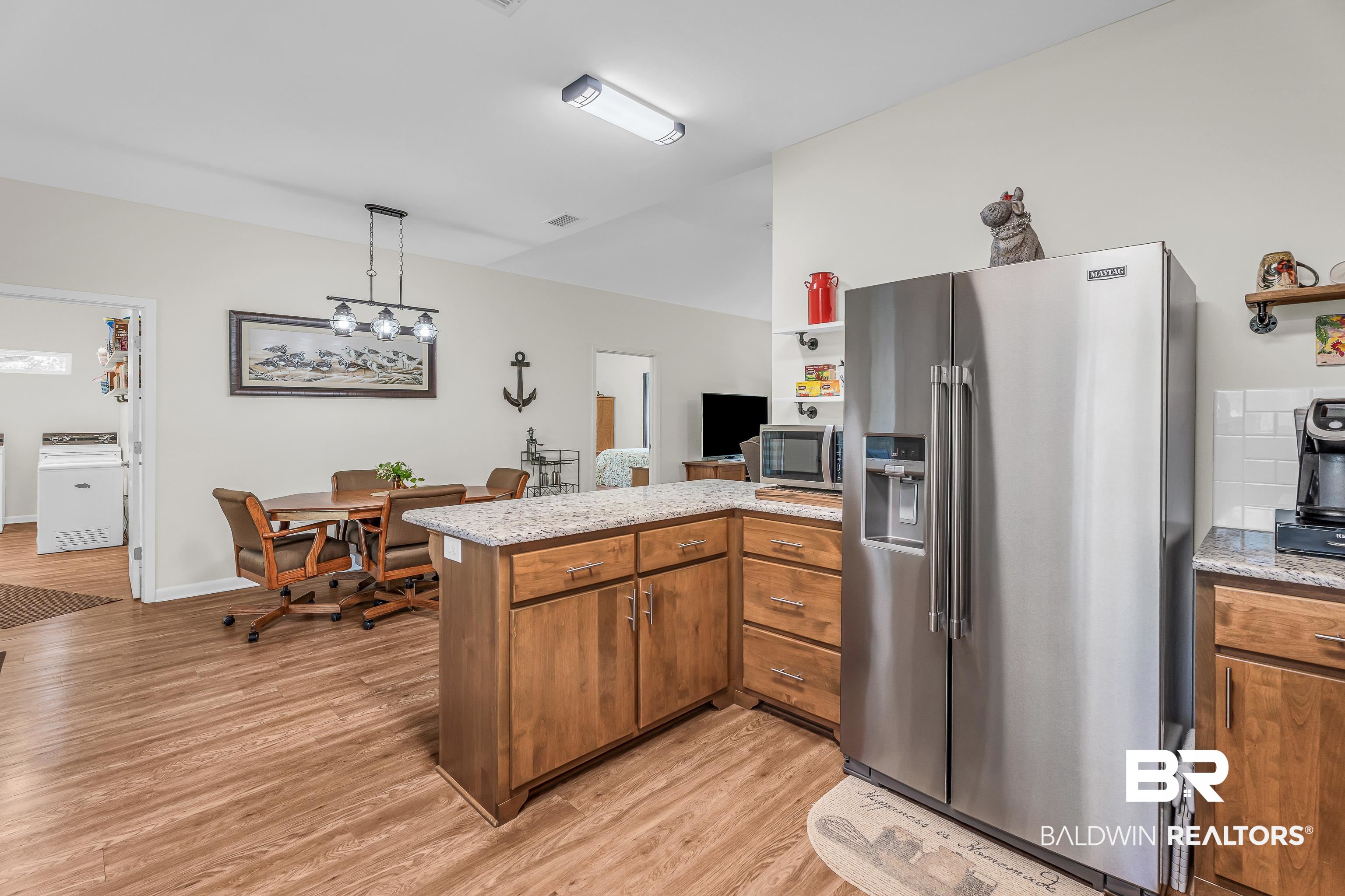 18255 Cactus Court Elberta, AL 36530 - Photo 18 of 53 Kitchen featuring stainless steel appliances, wood finish cabinetry, a peninsula, pendant lighting, and light wood finished floors