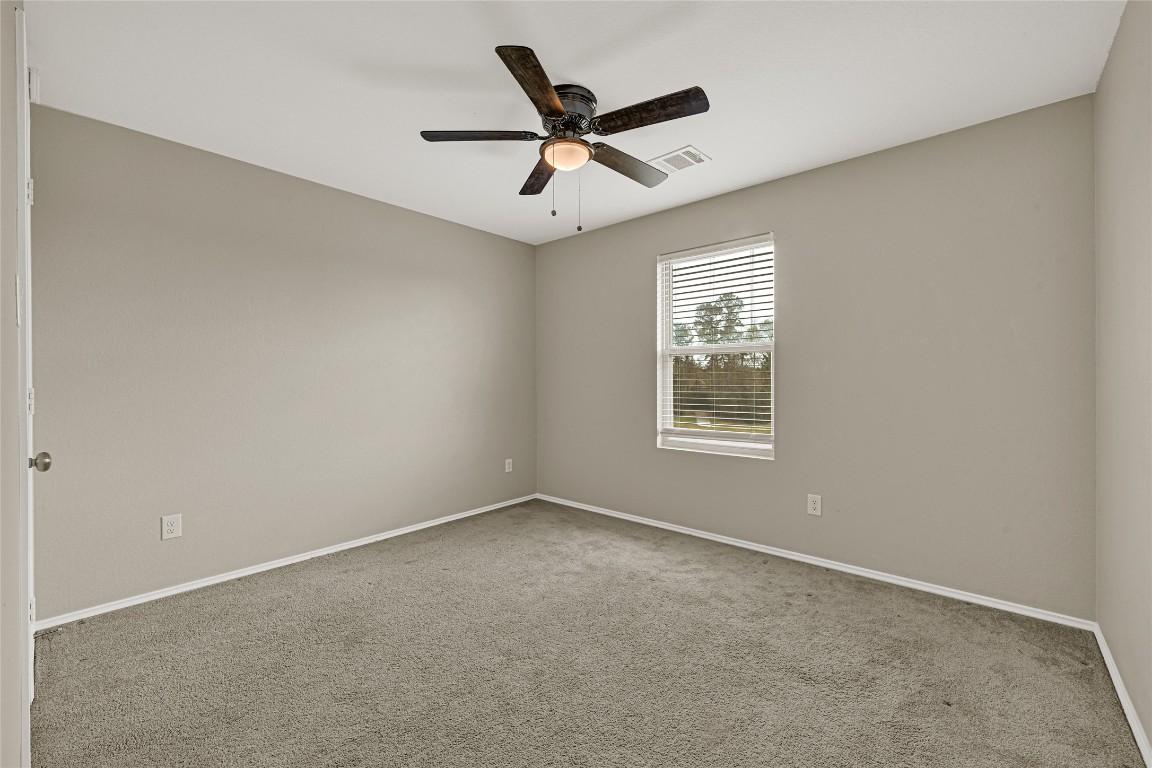 6020 Rimini Landing Lane Porter, TX 77365 - Photo 22 of 33 an empty room with ceiling fan and windows