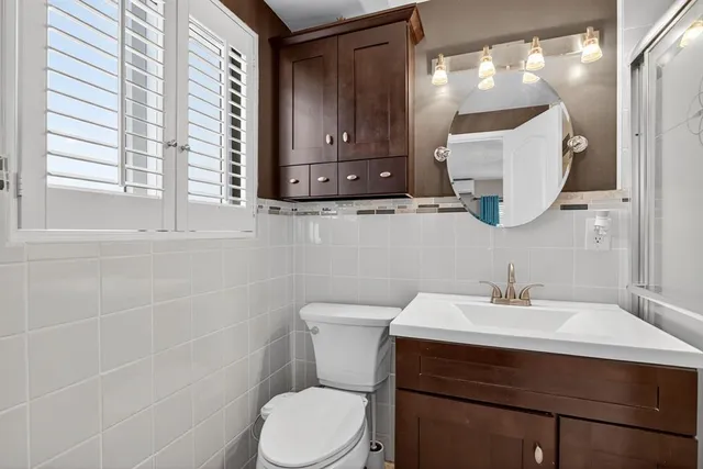 a bathroom with a sink vanity mirror and toilet