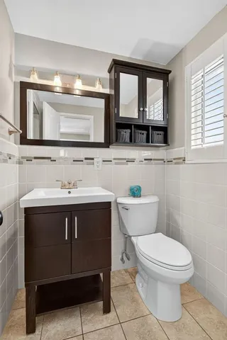 a bathroom with a sink vanity mirror and toilet