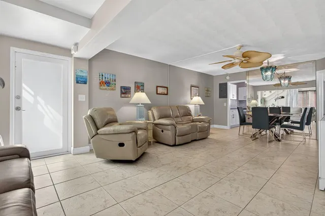 a living room with furniture and a dining table with kitchen view