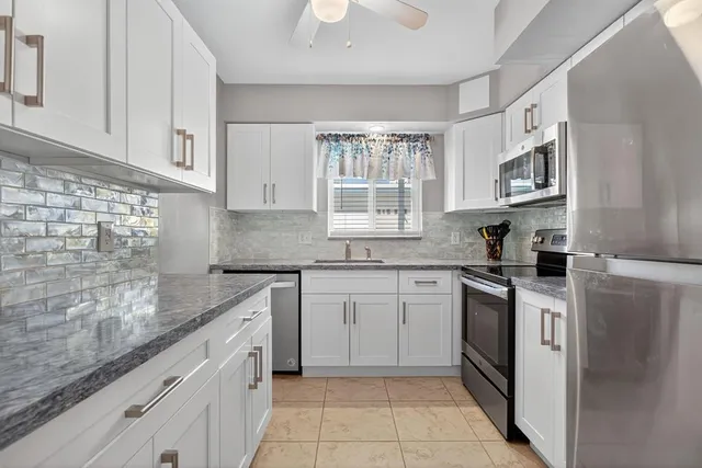 a kitchen with stainless steel appliances granite countertop a sink stove and refrigerator