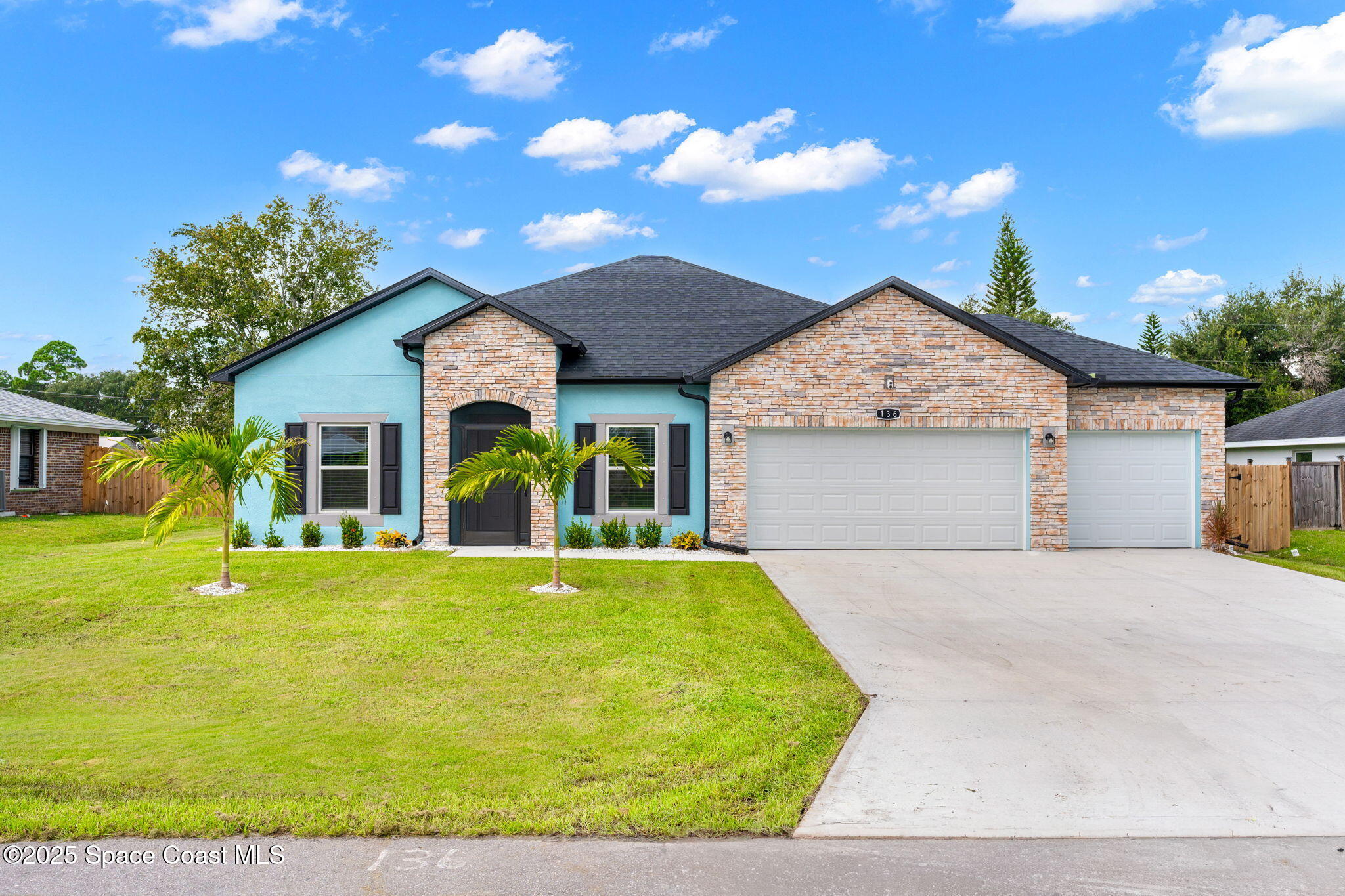 a front view of a house with a garden and yard