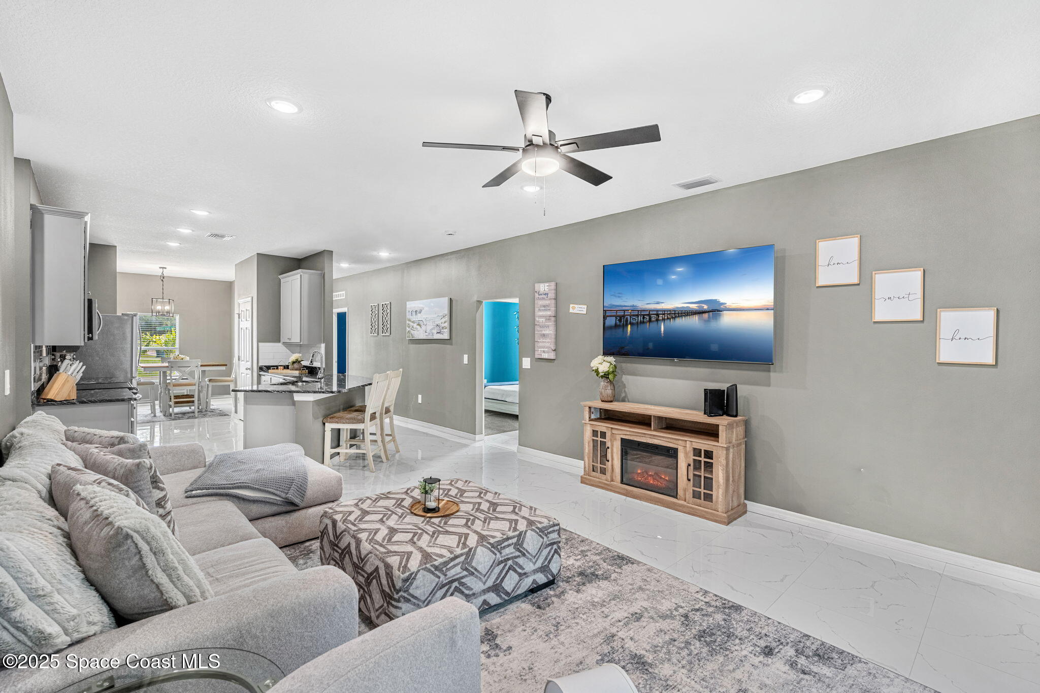 1125 Satin Road Palm Bay, FL 32908 - Photo 14 of 26 a living room with furniture a flat screen tv and kitchen view