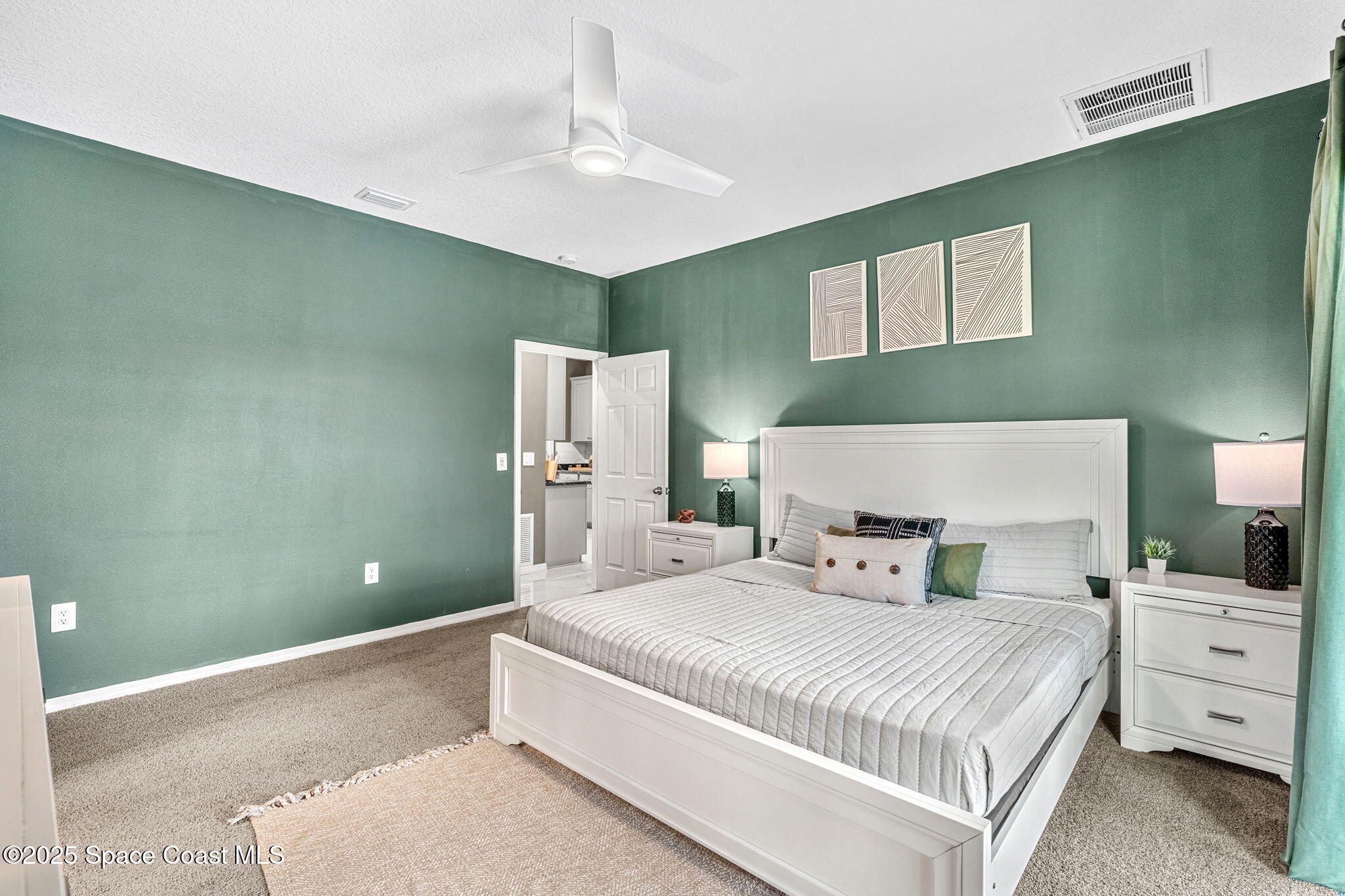 1125 Satin Road Palm Bay, FL 32908 - Photo 20 of 26 a bedroom with a large bed and a chandelier