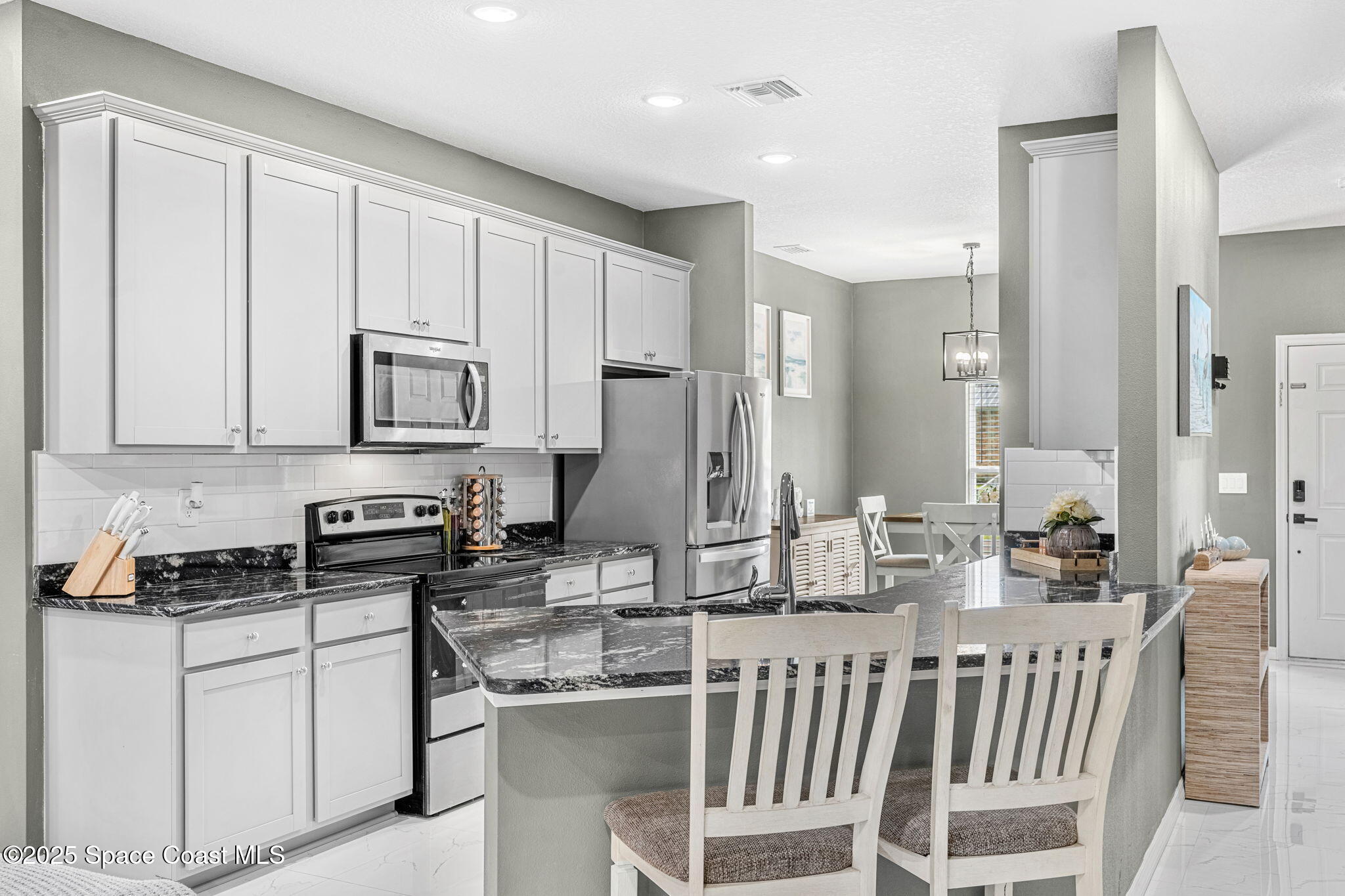 1125 Satin Road Palm Bay, FL 32908 - Photo 8 of 26 a kitchen with stainless steel appliances granite countertop a stove a sink and a refrigerator