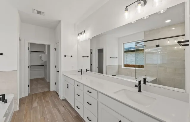 a large kitchen with stainless steel appliances kitchen island a large counter top a sink cabinets and a wooden floor