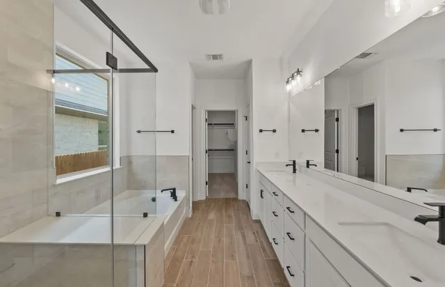 a bathroom with a double vanity sink and mirror