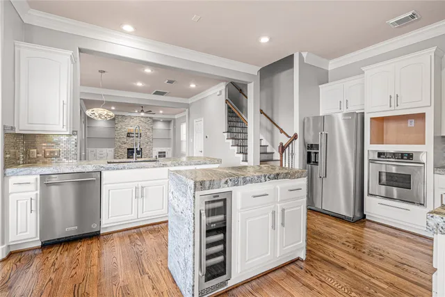 a kitchen with white cabinets and stainless steel appliances
