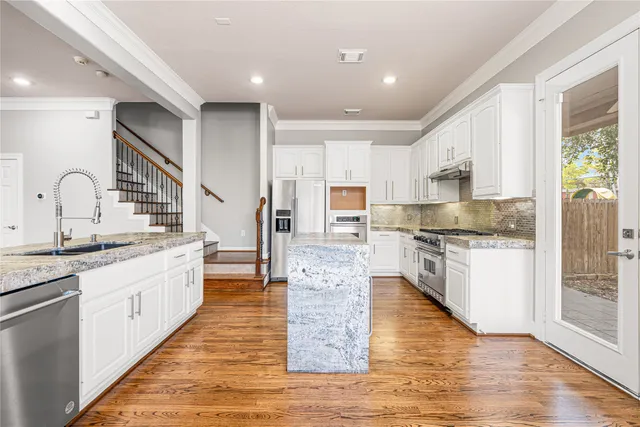 a large kitchen with stainless steel appliances lots of counter space and wooden floor