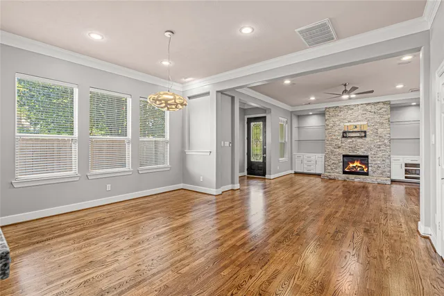 a view of empty room with wooden floor and windows