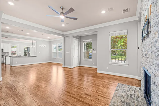 a view of an empty room with window and wooden floor