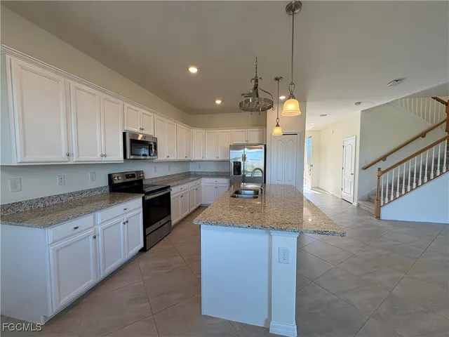 a kitchen with stainless steel appliances granite countertop a sink a stove and a refrigerator