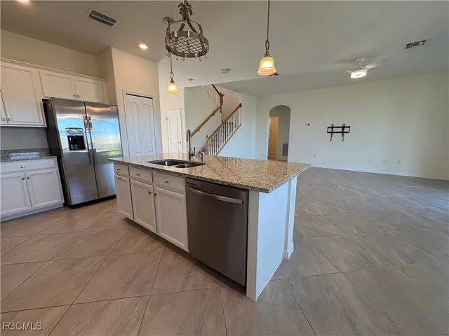 a kitchen with stainless steel appliances granite countertop a sink a stove and a refrigerator