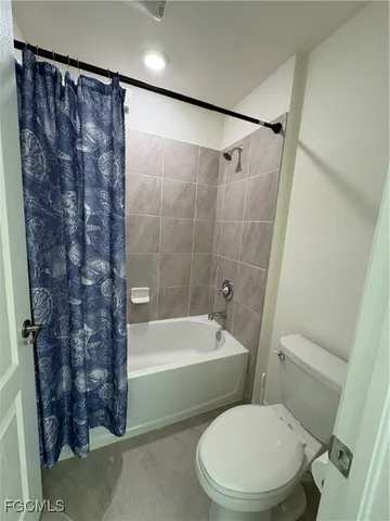 a white toilet sitting next to a bath tub shower