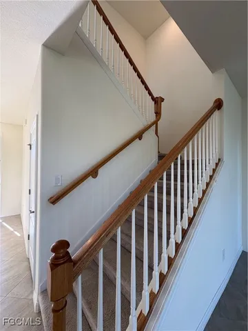 a view of staircase with railing and white walls