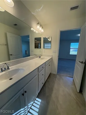 a spacious bathroom with a double vanity sink and a mirror