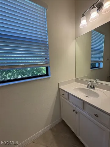 a bathroom with a granite countertop sink and mirror