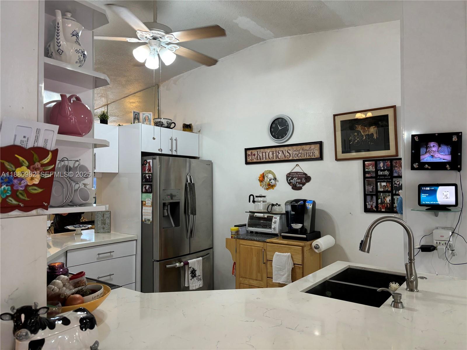 12343 Southwest 195th Terrace Miami, FL 33177 - Photo 11 of 45 a kitchen with stainless steel appliances a refrigerator a stove a sink a dining table and chairs with the front door