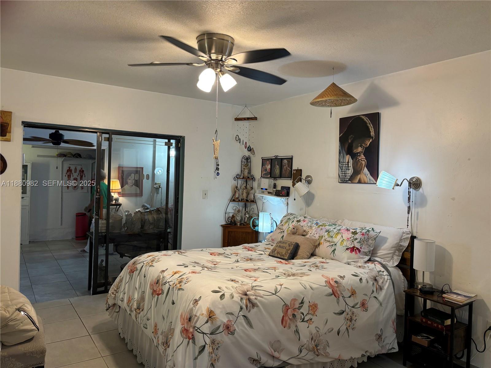12343 Southwest 195th Terrace Miami, FL 33177 - Photo 15 of 45 a bedroom with a bed and a chandelier