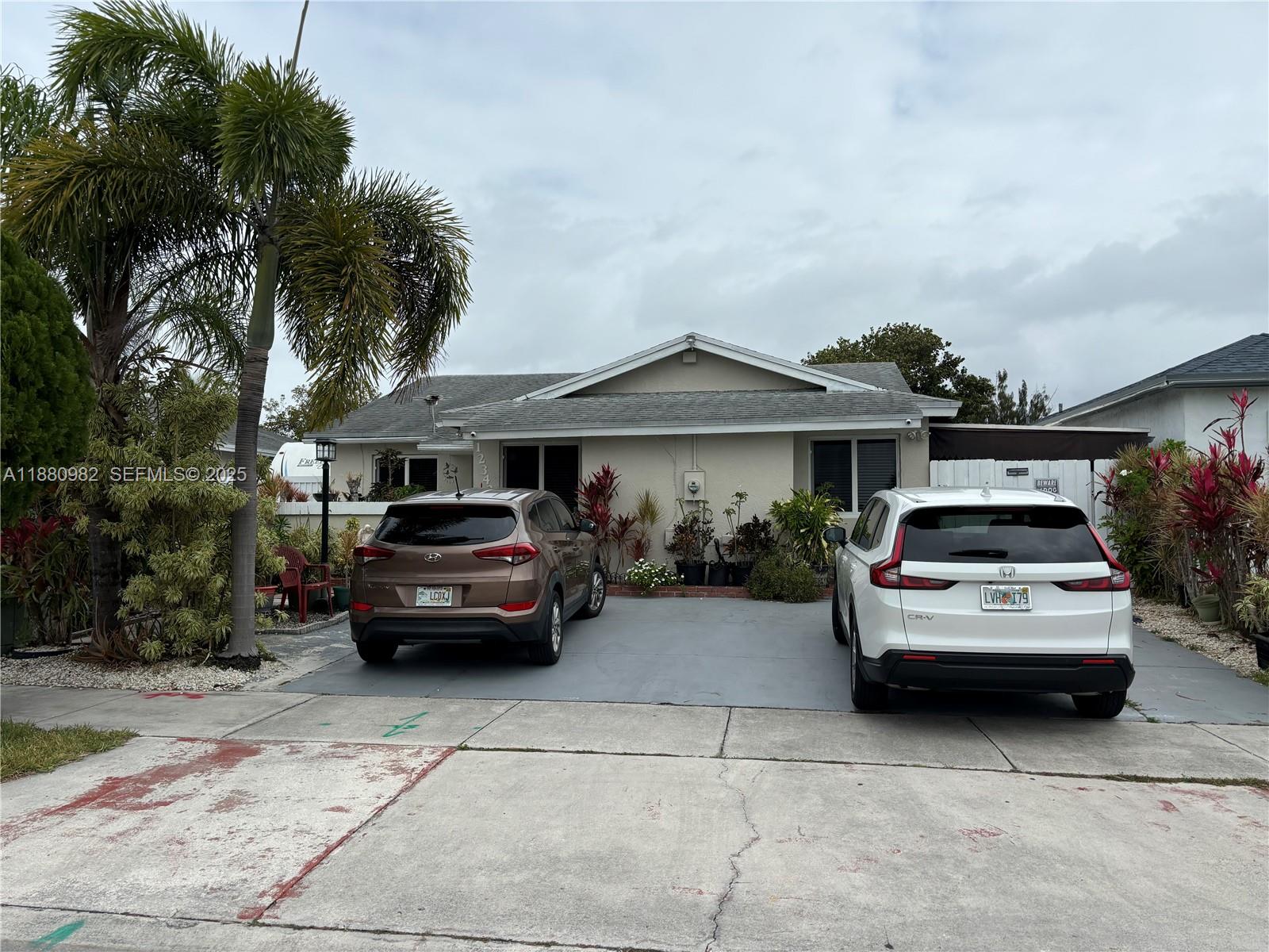 12343 Southwest 195th Terrace Miami, FL 33177 - Photo 2 of 45 a car parked in front of a house