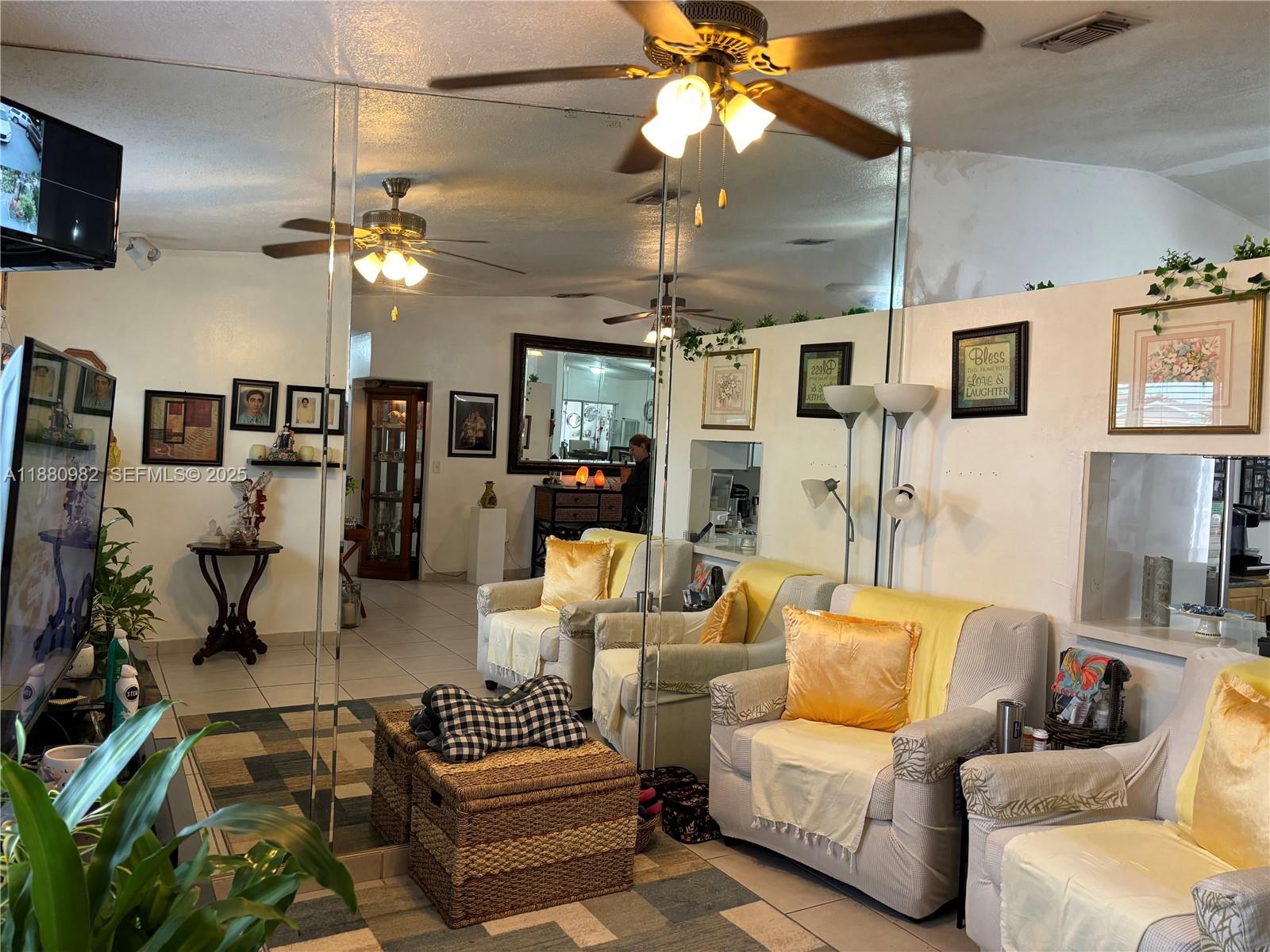 12343 Southwest 195th Terrace Miami, FL 33177 - Photo 4 of 45 a living room with furniture a chandelier and a flat screen tv