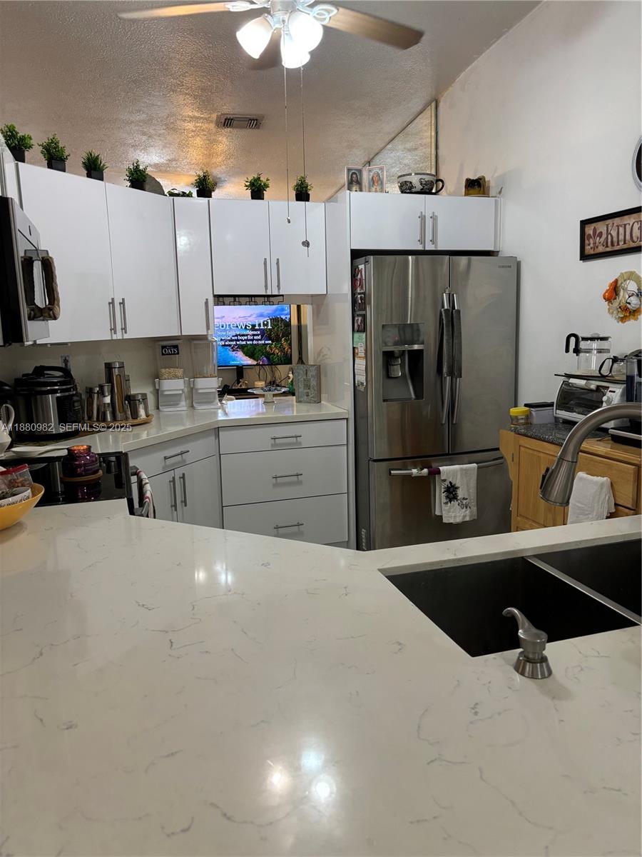 12343 Southwest 195th Terrace Miami, FL 33177 - Photo 43 of 45 a kitchen with stainless steel appliances a refrigerator sink and cabinets