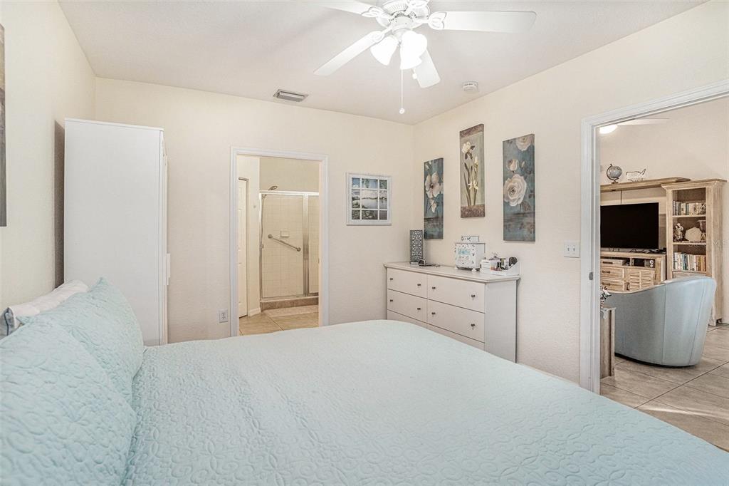 3588 Wembley Way, Unit 103 Palm Harbor, FL 34685 - Photo 18 of 35 a bedroom with a bed and a flat screen tv