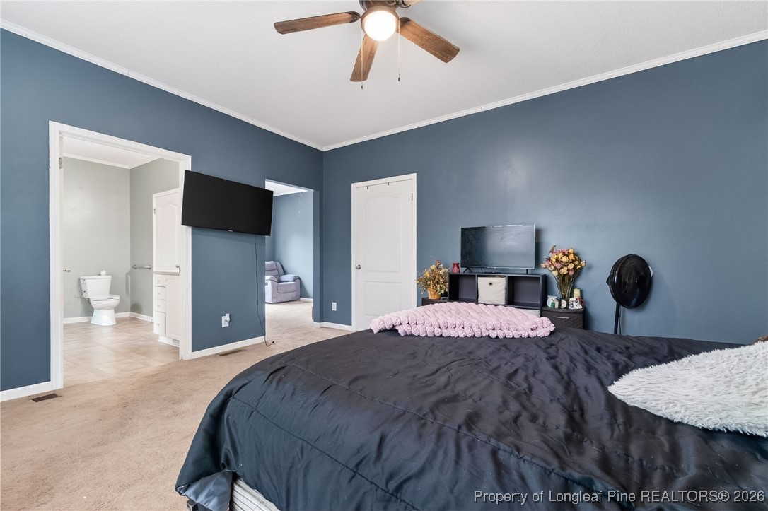 121 Prairie Lane Lillington, NC 27546 - Photo 14 of 40 a bedroom with a bed and a chandelier