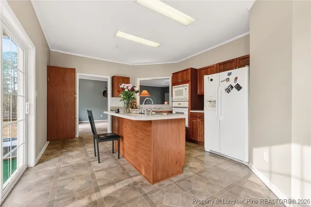 a room with kitchen island a sink and a large mirror