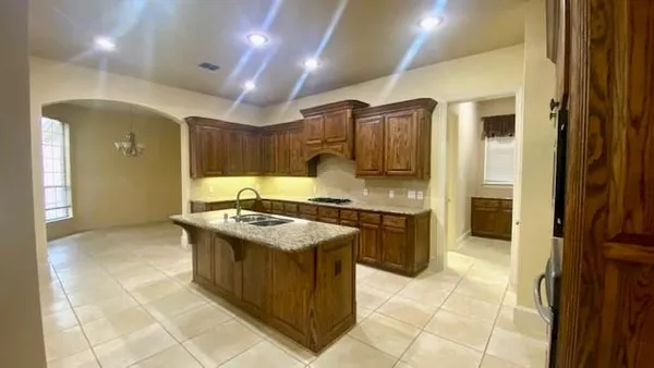 a kitchen with stainless steel appliances granite countertop a stove top oven a sink dishwasher and cabinets with wooden floor