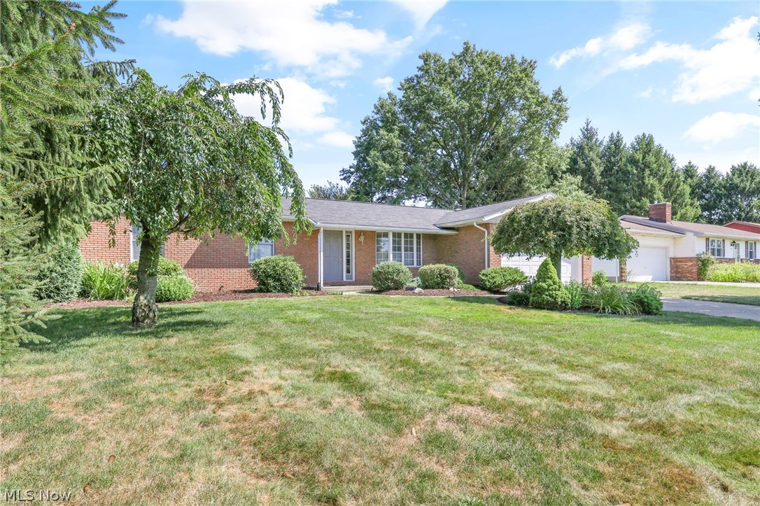 Single story home featuring a garage and a front lawn