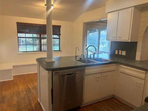 a kitchen with a sink cabinets and wooden floor