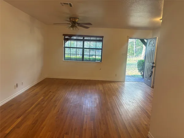 wooden floor in an empty room with a window