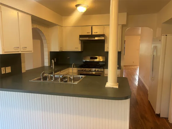 a kitchen with a sink a counter top space and stainless steel appliances