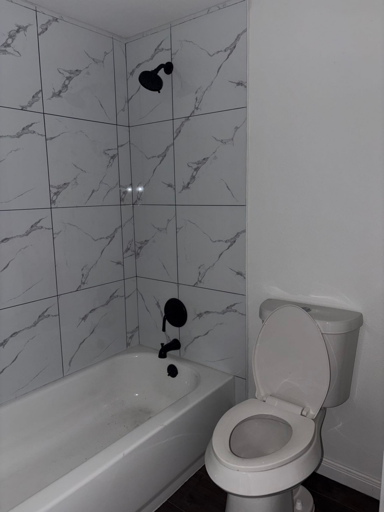 5782 Belcrest Street Houston, TX 77033 - Photo 13 of 18 a white toilet and a bathtub in a bathroom