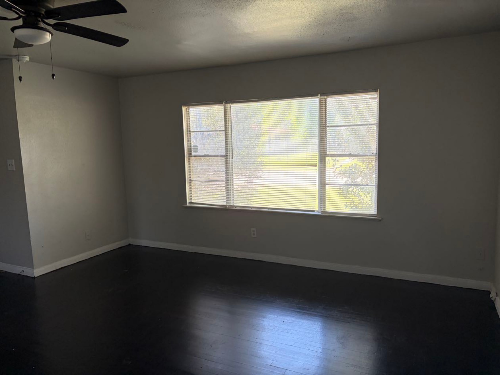 5782 Belcrest Street Houston, TX 77033 - Photo 7 of 18 a view of an empty room with wooden floor and a window