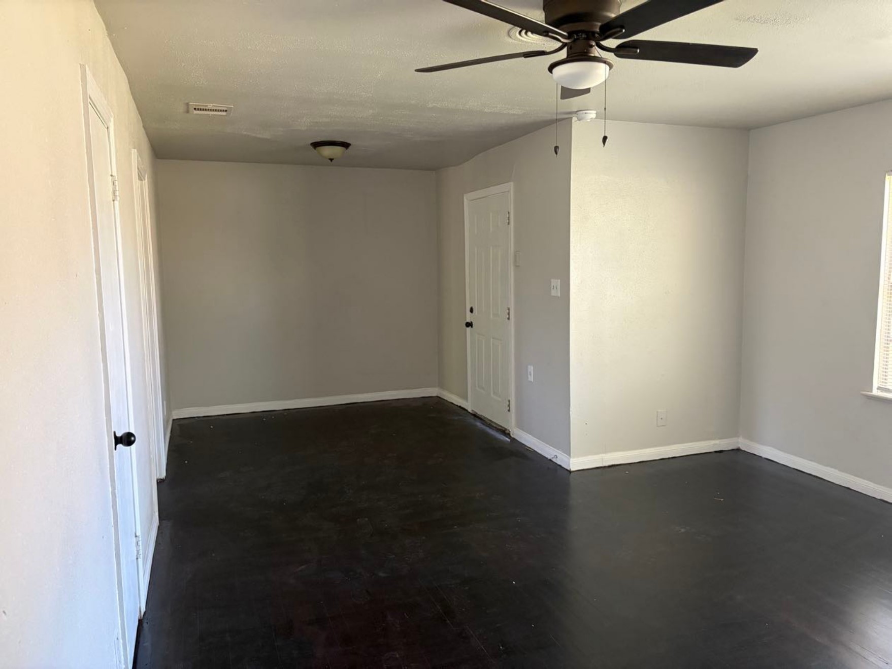 5782 Belcrest Street Houston, TX 77033 - Photo 9 of 18 an empty room with wooden floor fan and windows