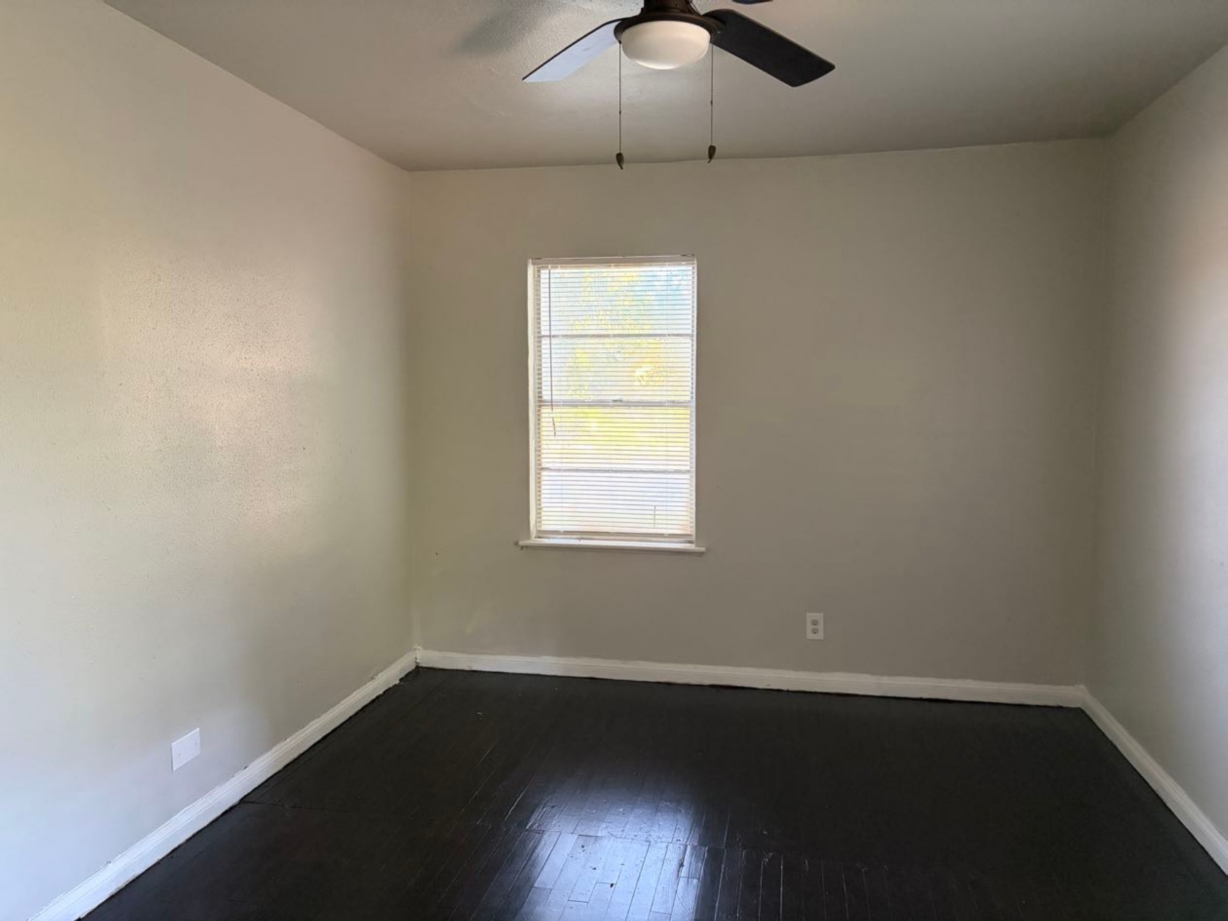 5782 Belcrest Street Houston, TX 77033 - Photo 10 of 18 wooden floor in an empty room with a window
