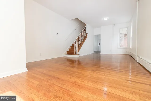 a view of empty room with wooden floor