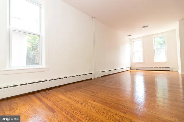 a view of a room with wooden floor and window