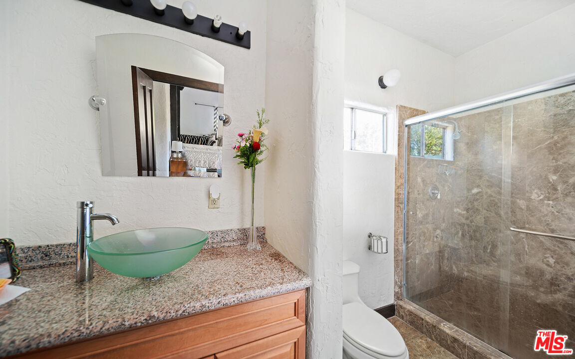 6611 Portshead Road Malibu, CA 90265 - Photo 11 of 19 a bathroom with a granite countertop sink and mirror