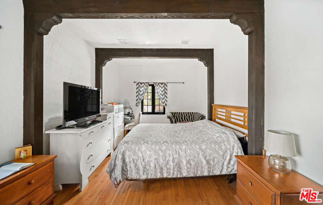 6611 Portshead Road Malibu, CA 90265 - Photo 10 of 19 a bedroom with a bed and flat tv screen on dresser
