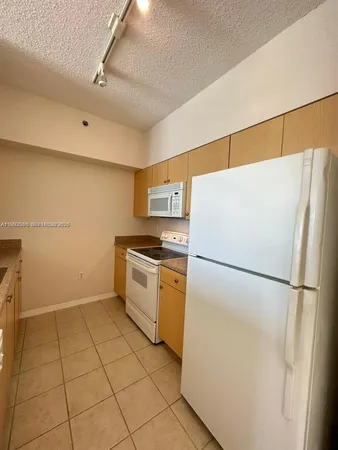 a white refrigerator freezer and a stove sitting inside of a kitchen