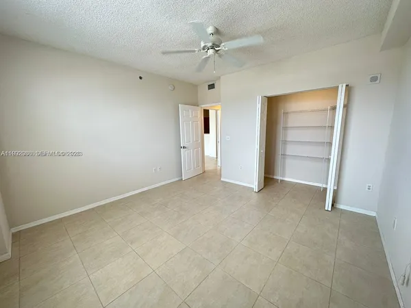 an empty room with closet and ceiling fan