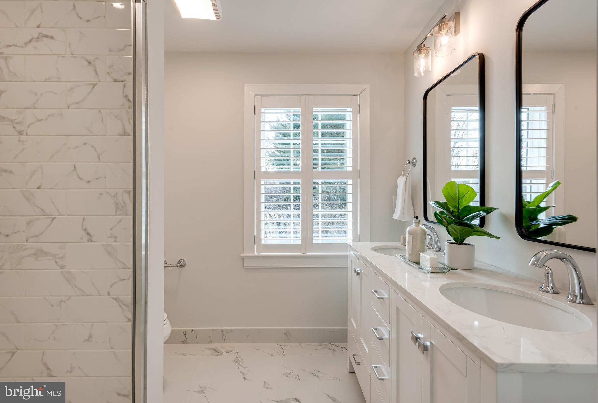 670 Leopard Road Berwyn, PA 19312 - Photo 33 of 52 a bathroom with a granite countertop sink a large mirror a window and a shower